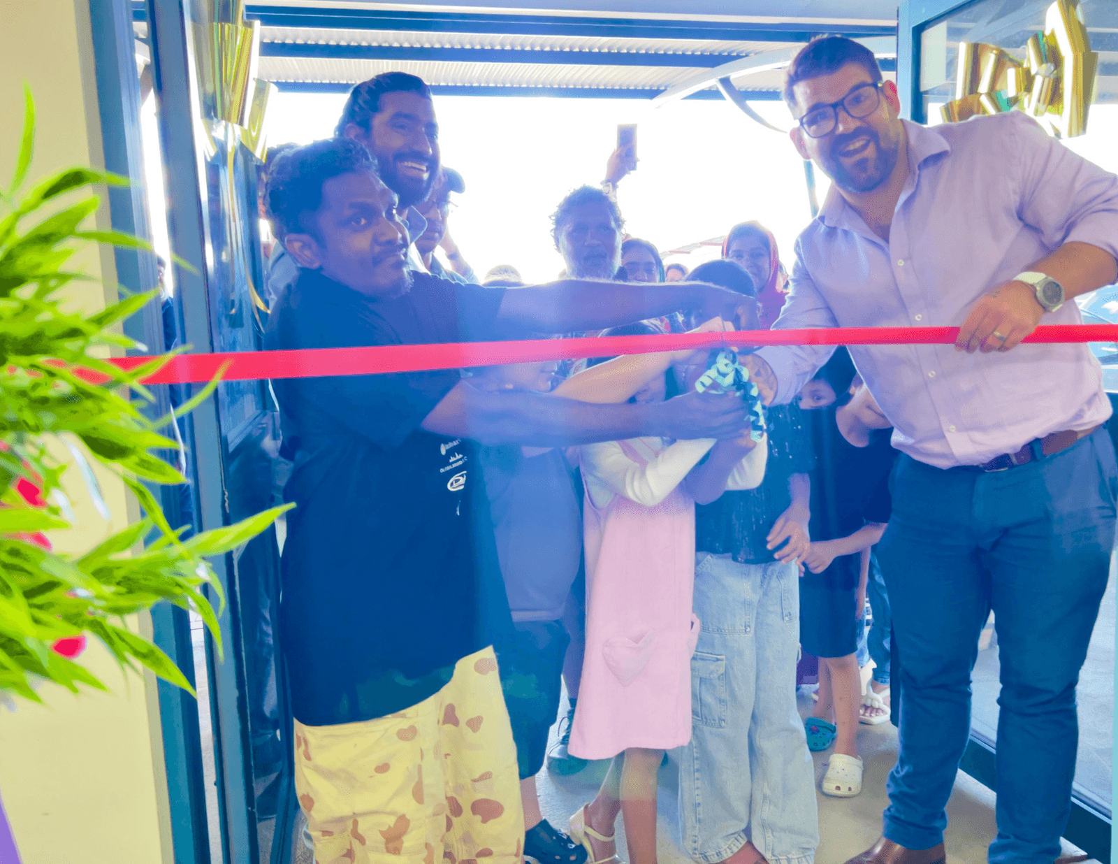 Participants, families and staff cutting the ribbon at the opening of the Evora Care Activity Centre in Alice Springs