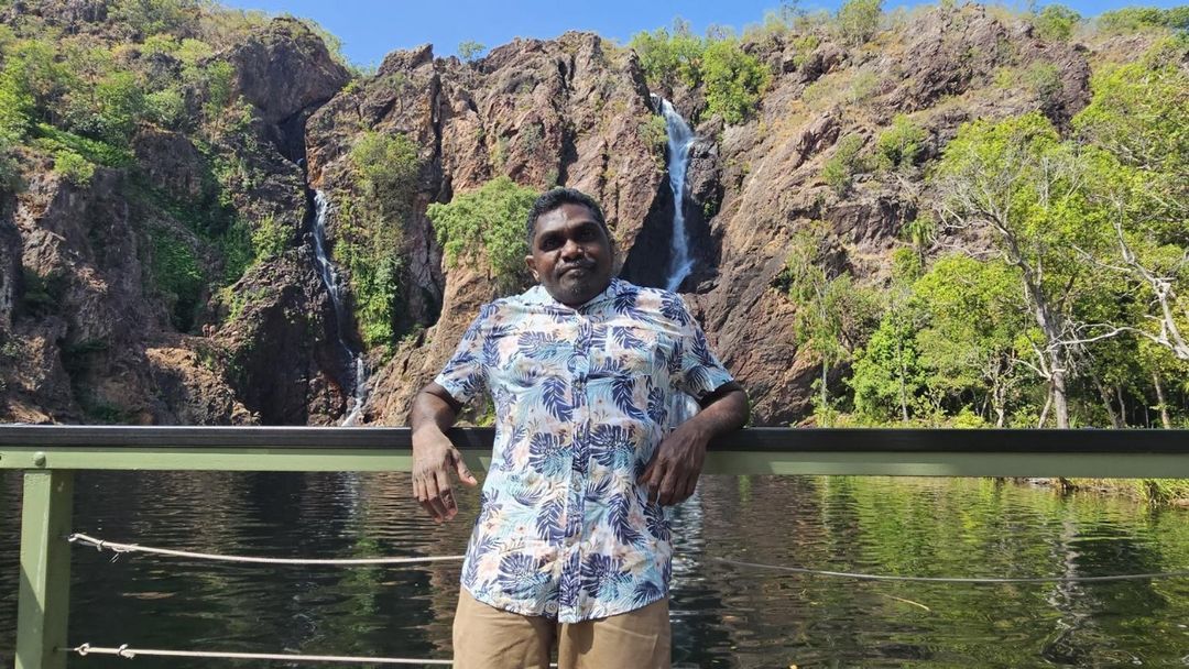 A participant at a waterfall on a supported trip
